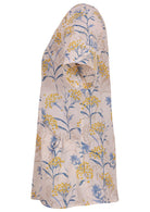 Side view of loose fit cotton blouse with pockets, short sleeves and round neckline in floral print on neutral background