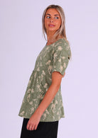 Model wears cotton long relaxed fit top with short sleeves and gathers under the bust