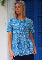 Model wears relaxed fit cotton short sleeve top with high round neckline and gathers under the bust