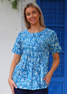 Woman wears blue floral print short sleeve cotton long top that sits over the derrière