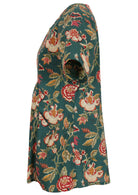 Side view of loose fit cotton blouse with pockets, short sleeves and round neckline in floral print on green background
