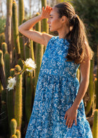 Woman in blue 100% cotton floral dress in front of flower cactus