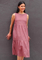 Woman with dark hair in Indian Cotton Sundress with three tiers in front of dark grey wall