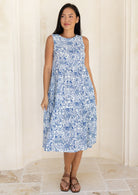 woman wearing a white based blue floral print relaxed fit cotton dress.