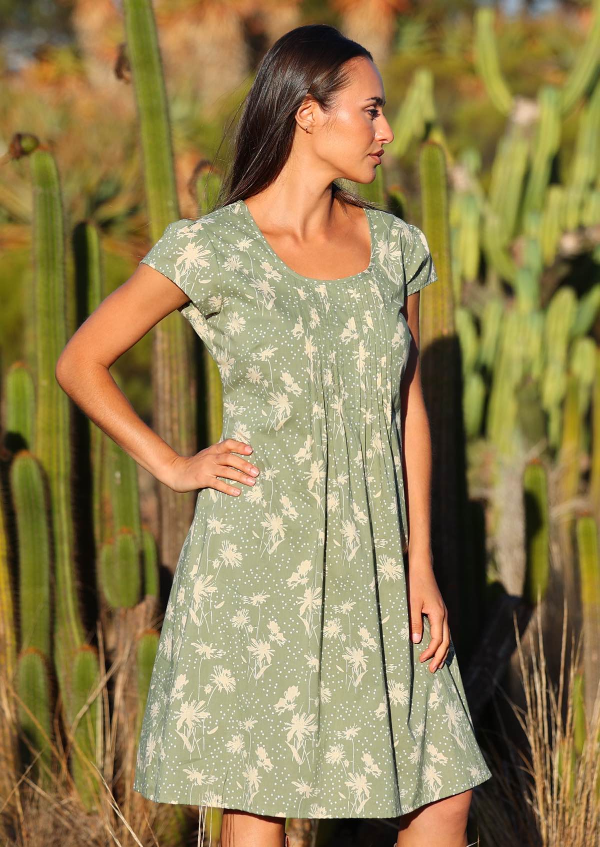 Woman stands with hand on hip in pale green based cotton short sleeve dress with lining