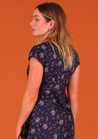 Woman modelling the back of 100 percent cotton short sleeve pleated sundress in deep purple Indian floral