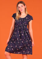 woman modelling 100 percent cotton short sleeve pleated sundress in deep purple Indian floral