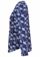Side image of long sleeve cotton top with navy blue based floral print.