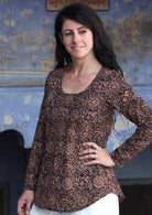 Model wearing 100% cotton long sleeve top in brown with round neckline and tiny pleat detail from the center of the neckline.
