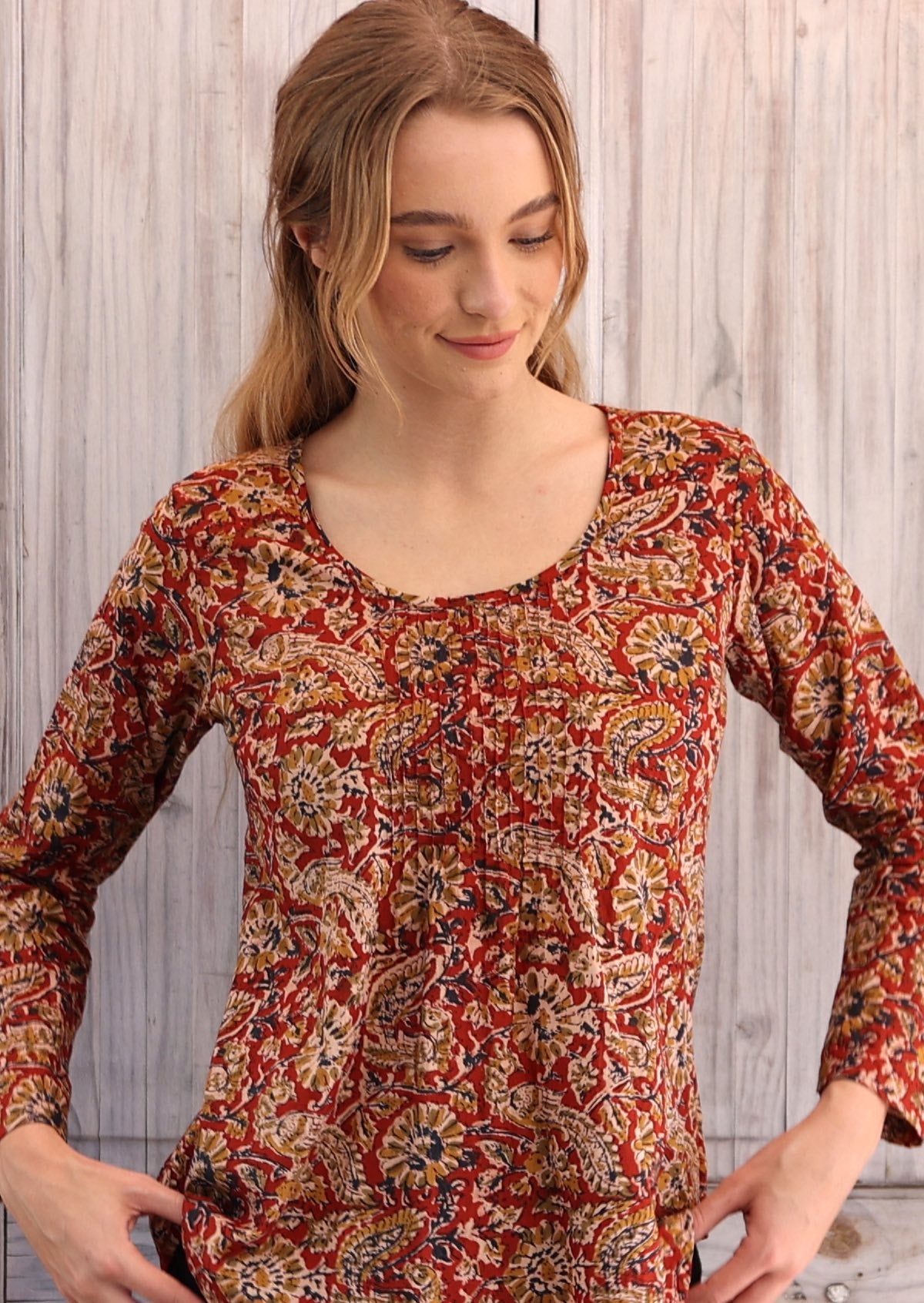 Woman wearing long sleeve earthy toned Indian print cotton blouse scoop neck with pleated detail 
