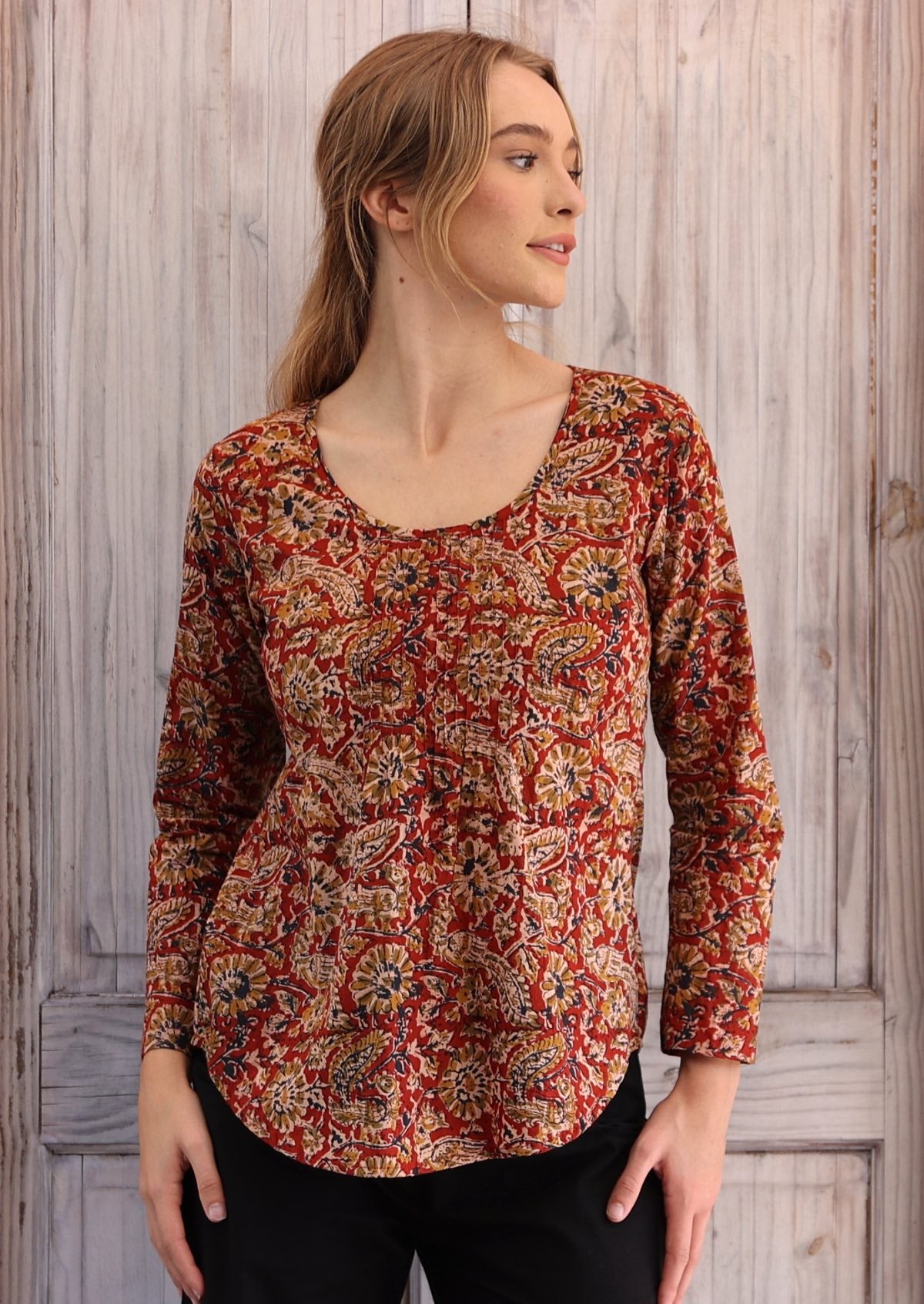Woman wearing long sleeve rust floral Indian print cotton blouse