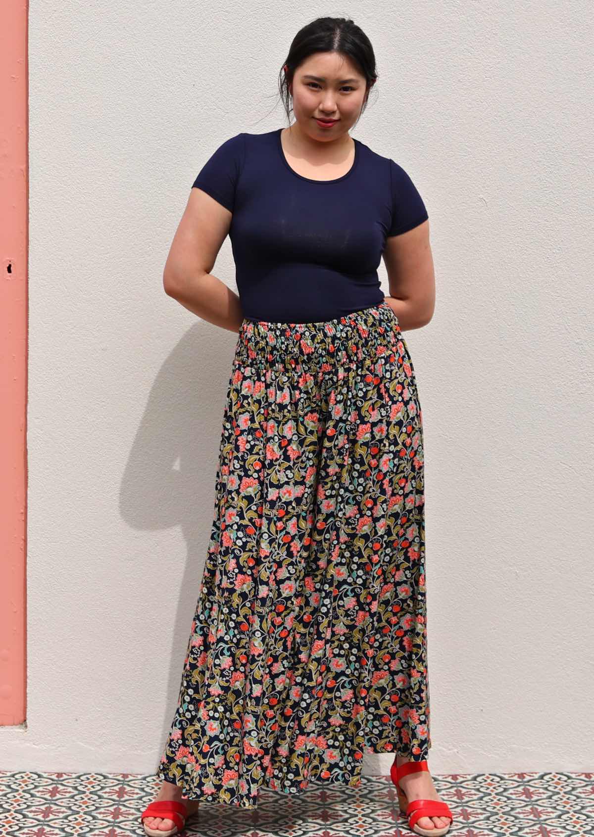 Model with hands folded behind back wearing rayon wide legged womens palazzo pant with elastic waist