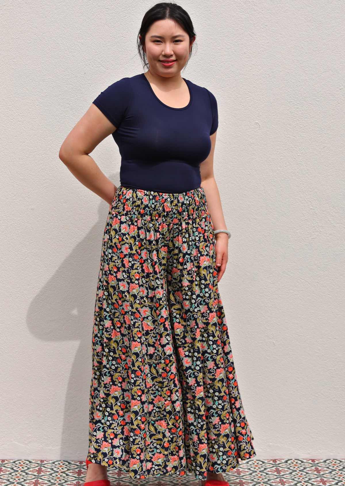 Model with one hand behind back wearing rayon wide legged womens palazzo pant with elastic waist