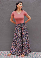 Woman wearing Indian print dark rayon wide leg pants with shirred waist band and pick t-shirt
