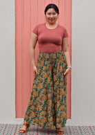 Woman in wide legged floral pants with shirred elastic waist 