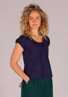 Model wears cap sleeved top with elastic trim in the sleeve allows for greater ease of movement