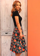 Stylised native flower print in red, green and white on a black base cotton skirt