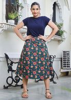 Woman wears knee length A line skirt in gorgeous green based floral print 