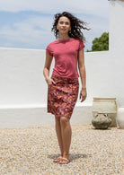 Woman wearing a above knee length A-line cotton skirt in Japanese style floral print with piped details, pockets and a side zipper.