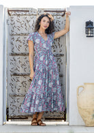 Model wears rayon maxi dress with tulip sleeves, V-neckline and voluminous skirt
