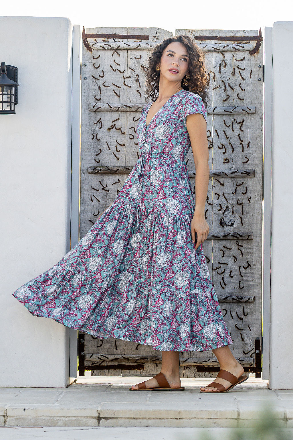 Woman wears rayon maxi dress with  voluminous tiered skirt and buttoned bodice