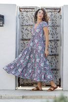 Woman wears rayon maxi dress with  voluminous tiered skirt and buttoned bodice