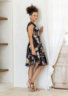 Model posing sideways in a beautiful 100% cotton dress with black based floral print