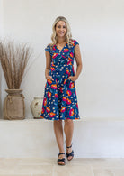 Model wears a 100% cotton dress featuring cap sleeves, pockets and a generous A-line skirt.