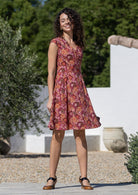 Woman wearing a cotton above knee dress with cap sleeves, pockets and generous skirt