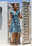 Model wears a 100% cotton dress featuring cap sleeves, pockets and a generous A-line skirt.