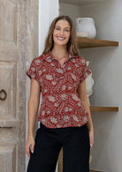 Woman poses in relaxed fit cotton short sleeve top with rolled cuffs sleeves, collar and V neckline.