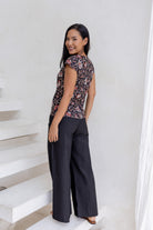 Model standing in a back pose wearing a 100% cotton tailored fit top with cap sleeves in indian floral print.