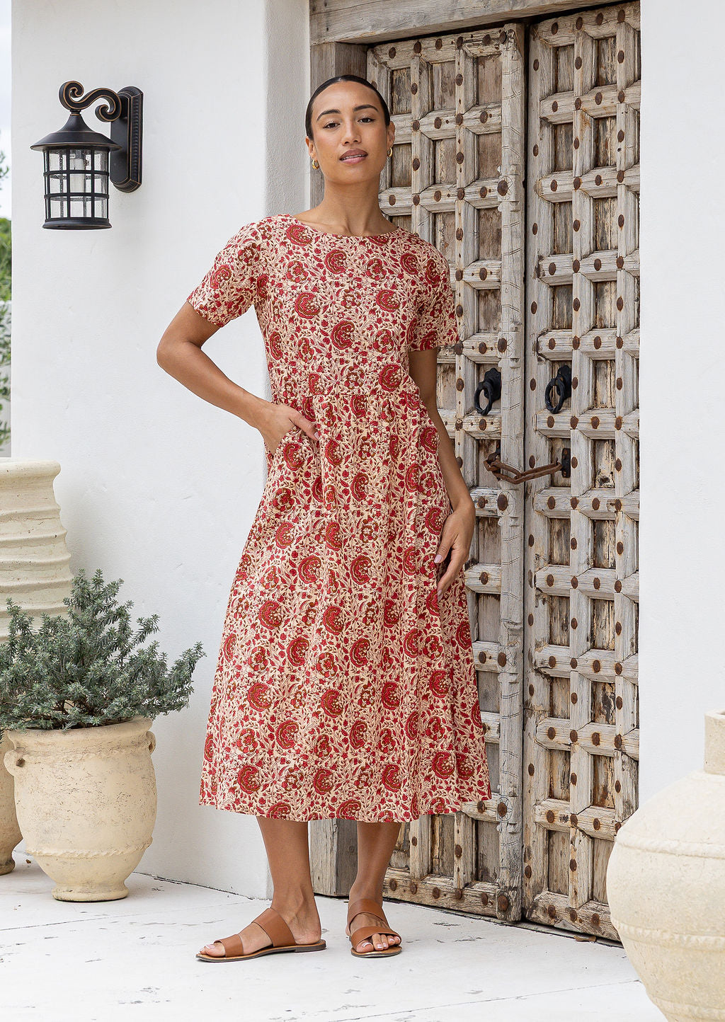 Model wearing a relaxed fit mid length 100% cotton dress with boat neckline, T shirt sleeves and pockets.