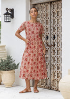 Model wearing a relaxed fit mid length 100% cotton dress with boat neckline, T shirt sleeves and pockets.