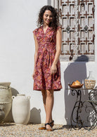 Woman wearing Japanese style floral print cotton dress with cap sleeves, box pleats and V neckline
