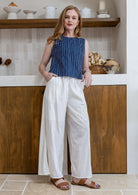 Model stands in white plain pants and relaxed fit floral print top with round neckline