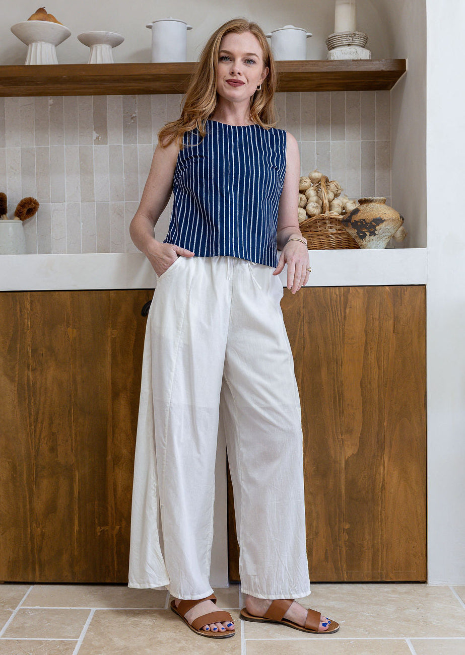 Model stands in white plain pants and relaxed fit floral print top with round neckline