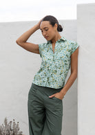 Model standing, wearing a 100% lightweight cotton button up shirt with folded cuff sleeves and collar