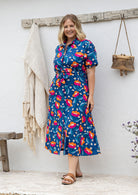 Model standing in a floral printed shirt dress with detachable fabric belt and short sleeves 