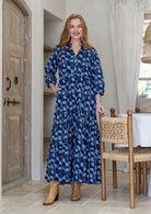 Woman standing with one hand in pocket of a 100% cotton flowy tiered maxi dress with 3/4 sleeves, buttoned bodice 