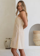 Cream petticoat cotton slip with thin straps, shown on a model, side view, knee length