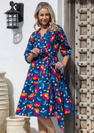 Model wearing 3/4 sleeved royal blue based floral print cotton wrap dress with V-neckline and pockets.