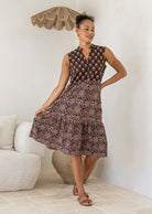 Woman wearing a brown Indian Cotton patterned dress in a living room setting