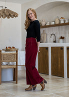 Woman stands sideways wearing a cotton corduroy wide leg pants with black basic top.
