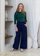 Woman in green basic top and blue cotton corduroy wide leg pants with wide waistband and pockets