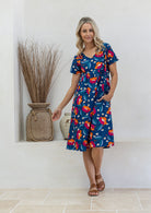 Model wearing a cotton V-neck short sleeve dress in royal blue based floral print 