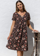 Model poses in a cotton V-neck short sleeve dress with empire waistline and  pocket.