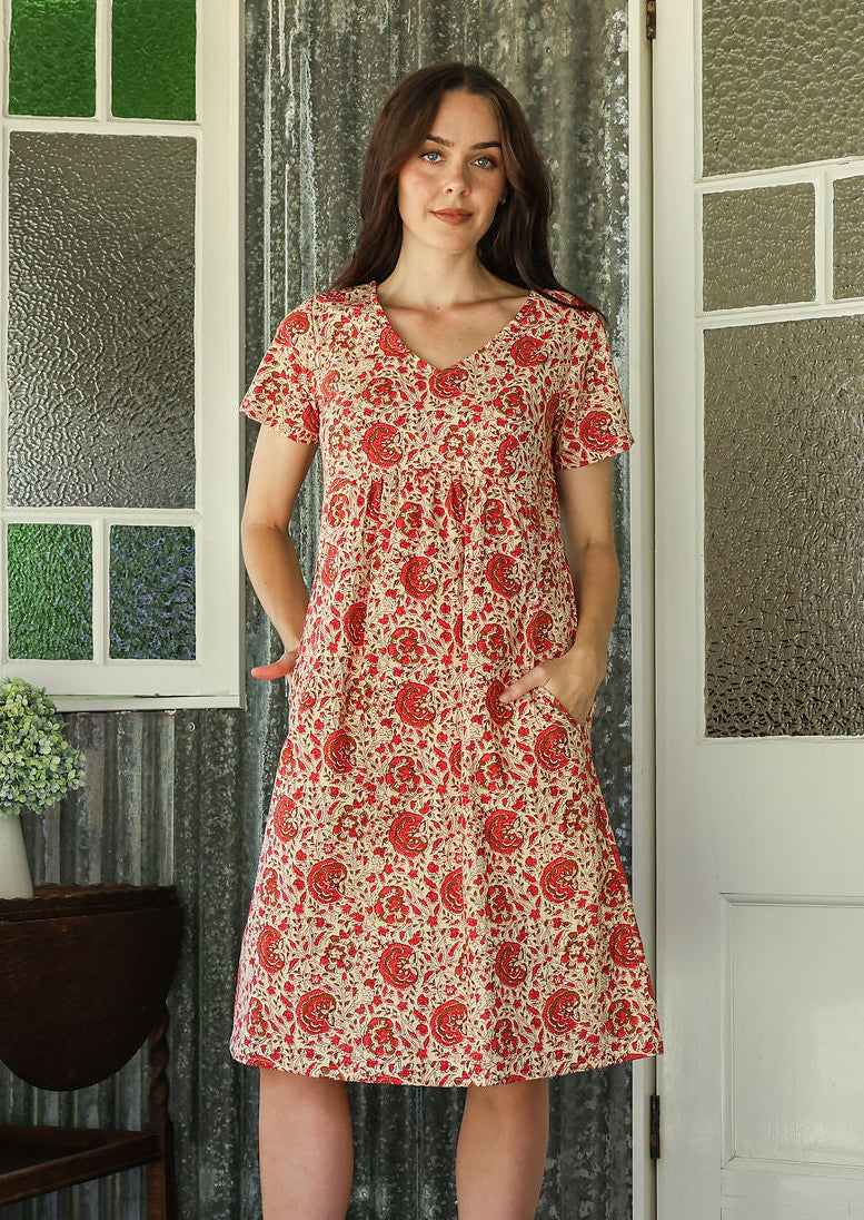 Model wearing a cotton V-neck short sleeve dress with empire waistline and  pocket.