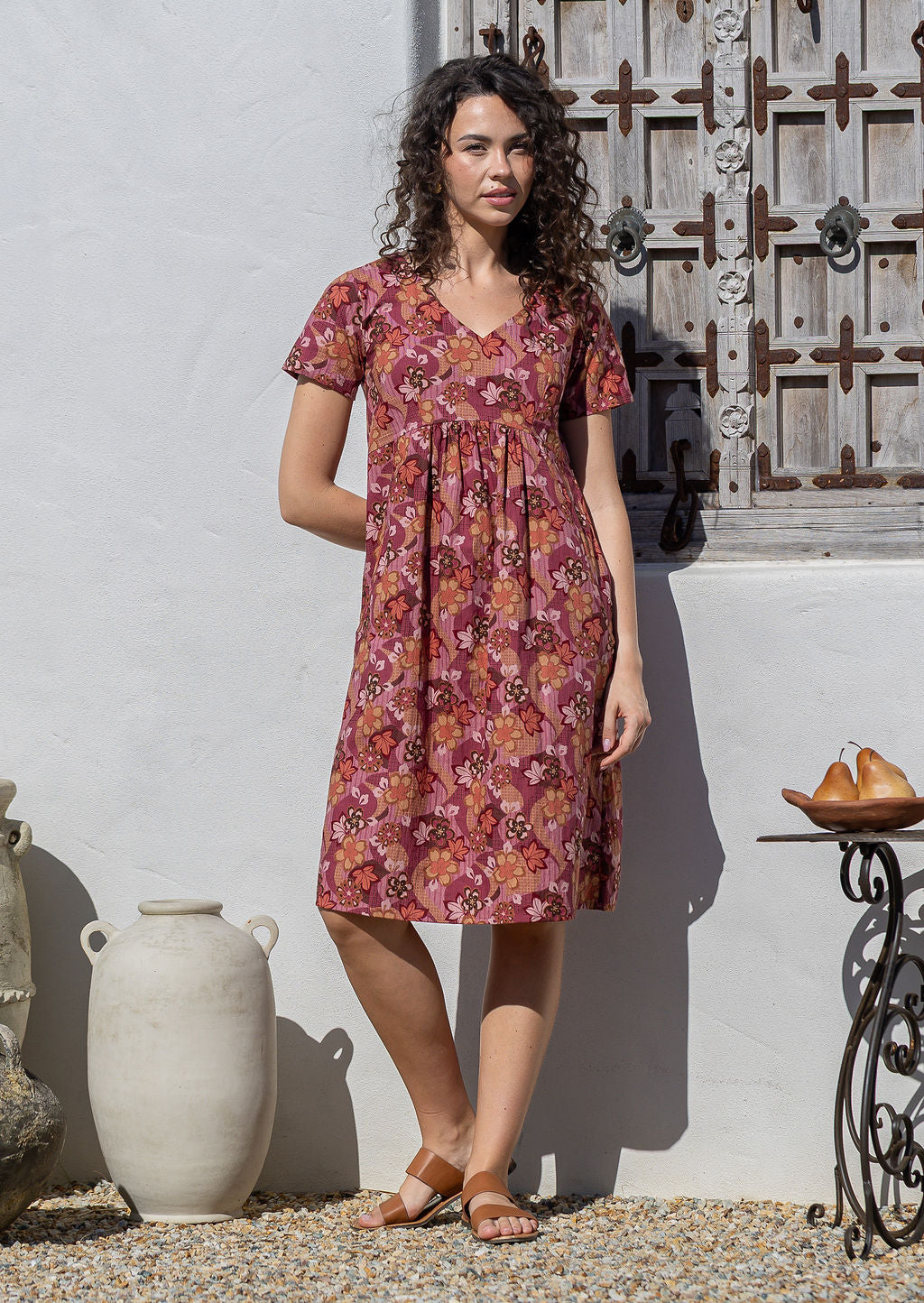 Model wearing a cotton knee length dress with empire waist, short sleeves and pockets.