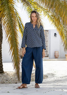 Woman in a navy blue based floral top with long sleeves and V neckline